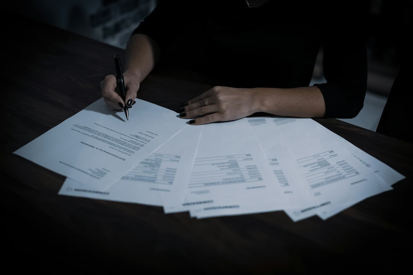 Person working through a spread of printed invoices