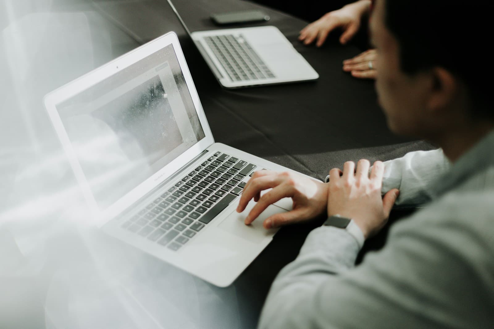 Two people working together at laptops