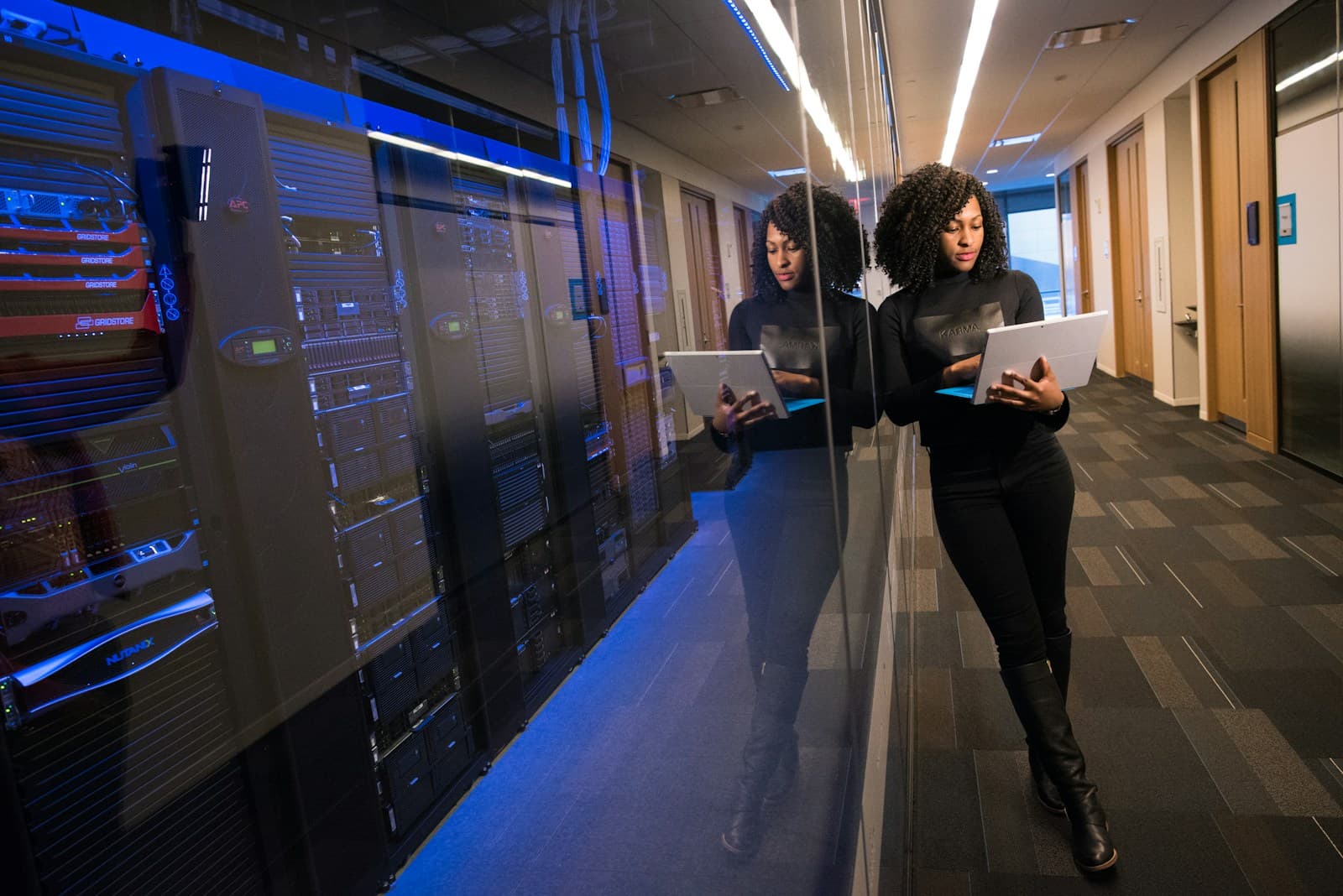 IT engineer checking systems on a laptop beside a row of server racks